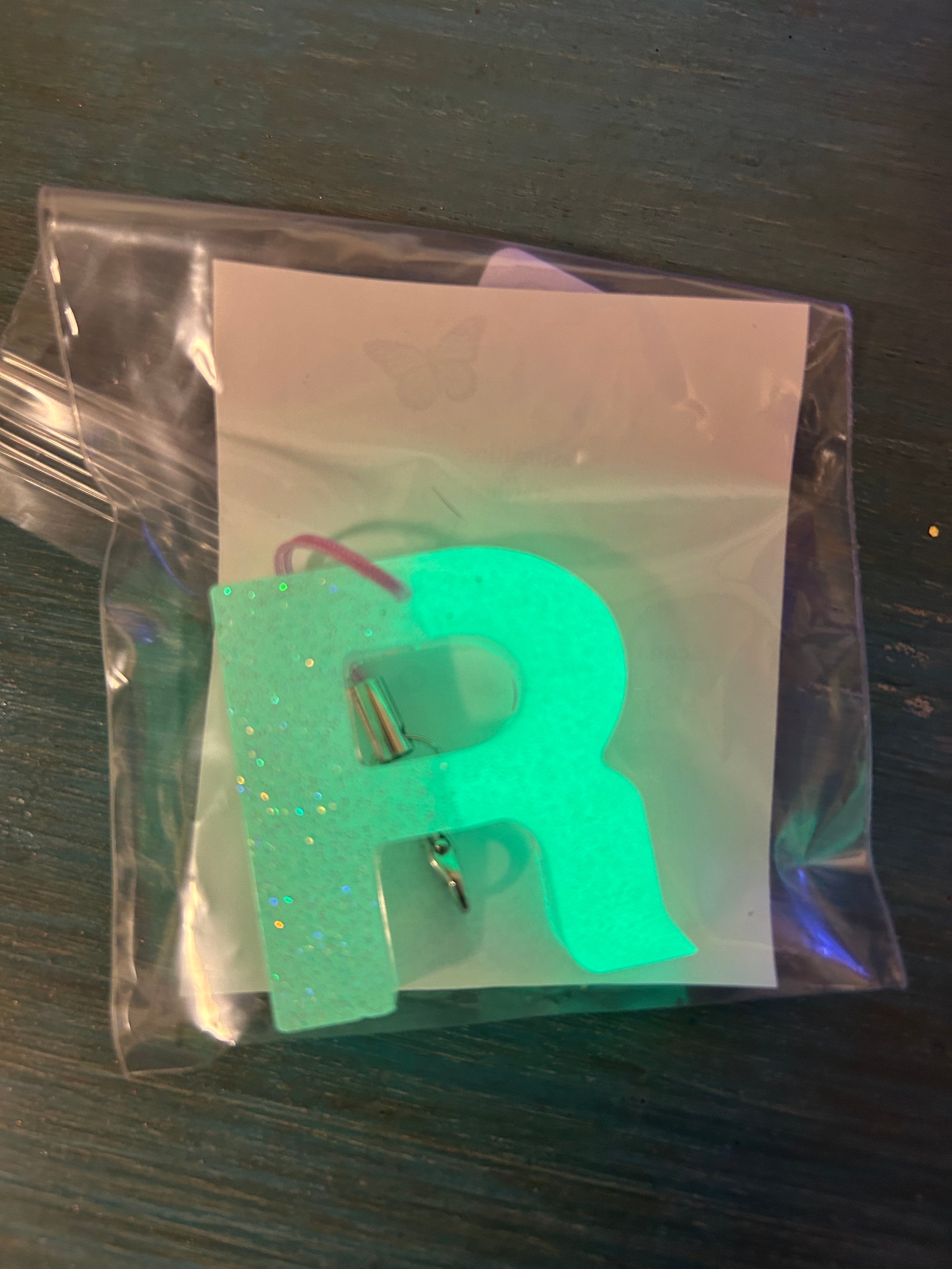 Letter charms/key chains/ bag clips (style color varies) some glow some don’t