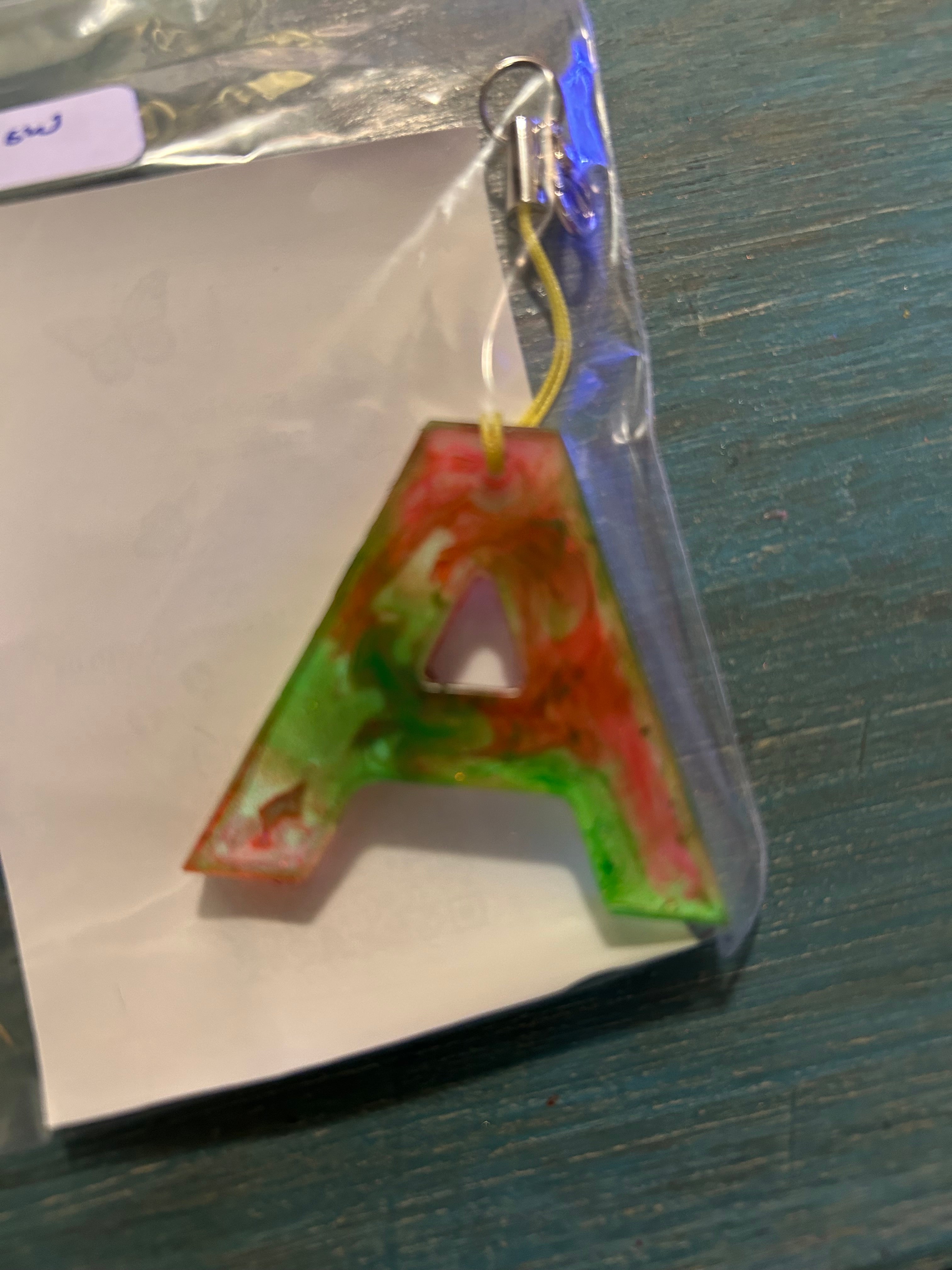 Letter charms/key chains/ bag clips (style color varies) some glow some don’t