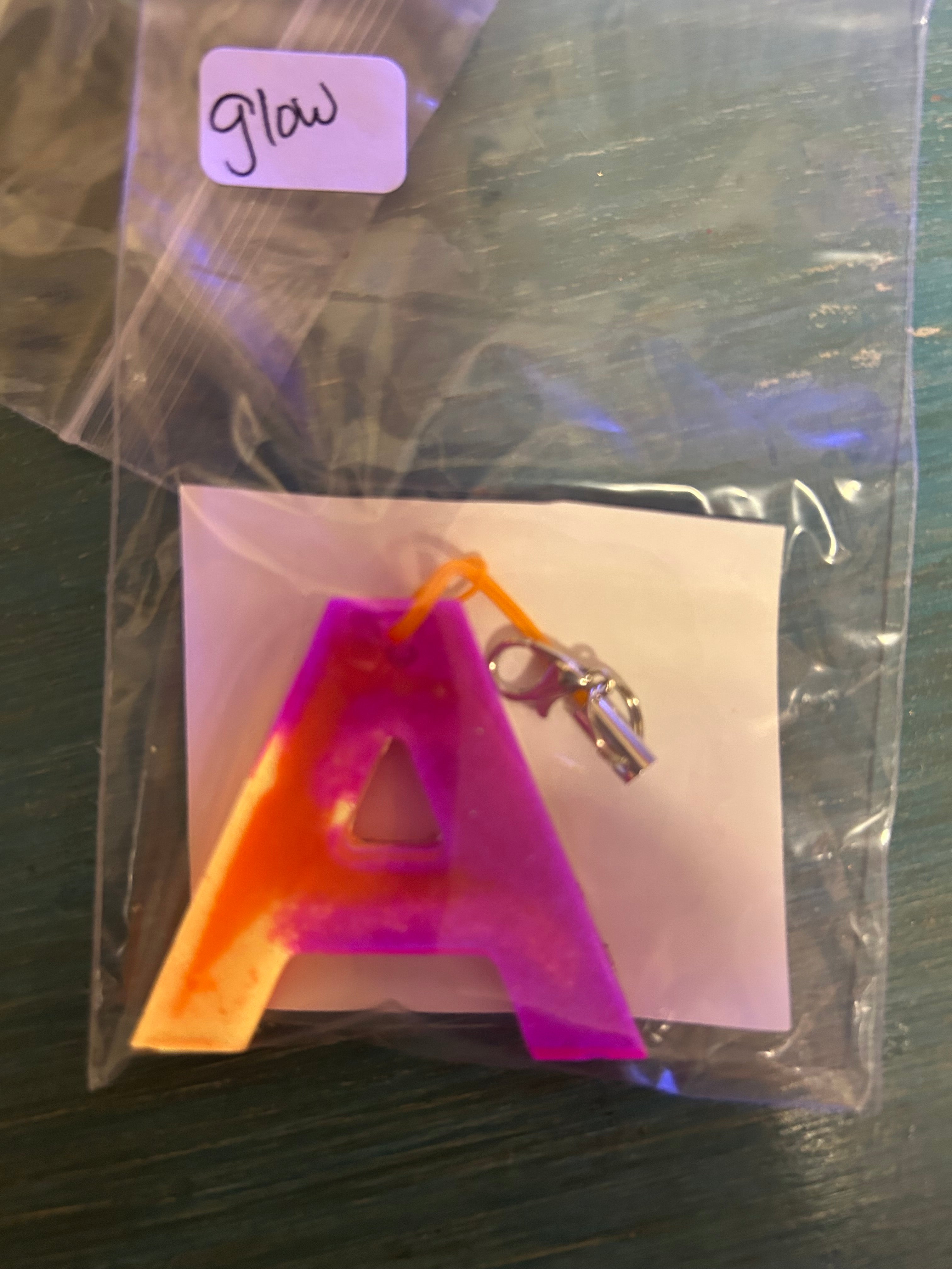 Letter charms/key chains/ bag clips (style color varies) some glow some don’t